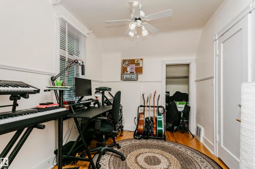 Room with wood-finish flooring, white walls, and a ceiling fan with integrated lighting - 11105 81 Avenue, Edmonton, AB 