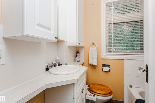 Bathroom vanity featuring a drop-in sink, white cabinetry, and a light-colored countertop - 11105 81 Avenue, Edmonton, AB 