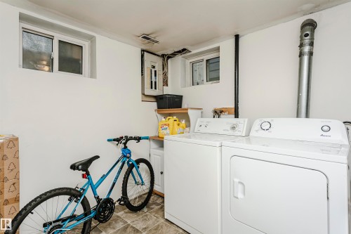 Laundry area featuring white walls, a white washing machine, and a white dryer - 11105 81 Avenue, Edmonton, AB 