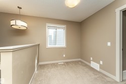 Carpeted interior space featuring a single window with blinds, a drum pendant light fixture, a flush mount ceiling light, and neutral wall paint - 