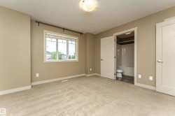 Carpeted room with a large window, a ceiling-mounted light fixture, and two panel doors - 