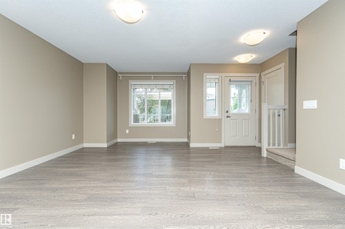 Spacious interior featuring wood-finish flooring, neutral wall tones, white trim, and ample natural light from multiple windows - 2397 Glenridding Boulevard, Edmonton, AB 