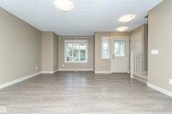 Spacious interior featuring wood-finish flooring, neutral wall tones, white trim, and ample natural light from multiple windows - 