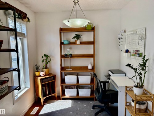 Bright room with white walls, wood-finish flooring, and a window with blinds - 184 1804 70 Street, Edmonton, AB 