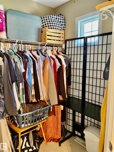 Closet space featuring wire shelving, a window providing natural light, and neutral-toned walls - 184 1804 70 Street, Edmonton, AB 