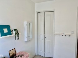 White bi-fold closet doors with round hardware, flanked by smooth white walls - 