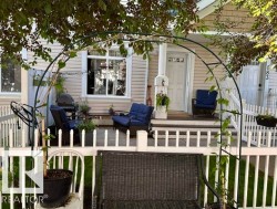 Front porch featuring a white picket fence, covered entry, and light-colored siding - 