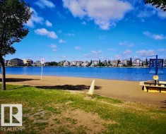 Lakeside setting with a sandy beach and green space - 