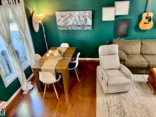 Dining area with wood-finish flooring and a rectangular dining table - 184 1804 70 Street, Edmonton, AB 