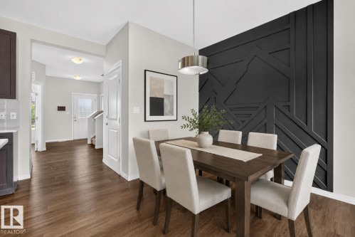 Dining area featuring a prominent dark accent wall with geometric paneling - 2144 51 Street, Edmonton, AB 