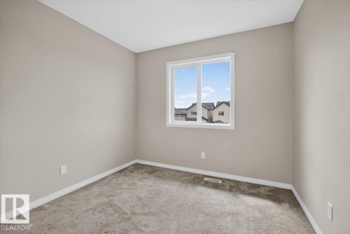 Neutral-toned interior room featuring light gray walls, white trim, and a white framed window - 2144 51 Street, Edmonton, AB 