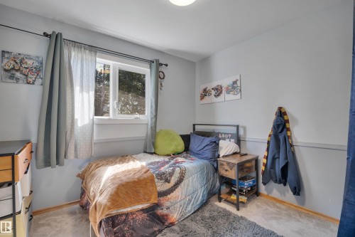 Bedroom featuring light gray walls, white trim, and a double-pane window - 9835 74 Street, Edmonton, AB 