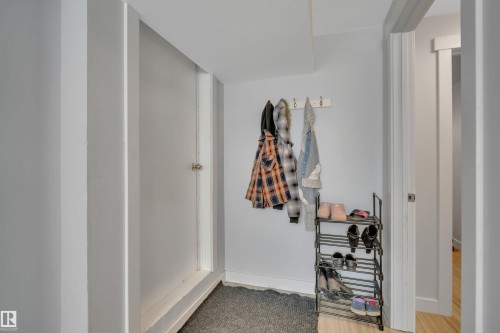 Light gray wall finish with white trim, wood-finish flooring, recessed lighting, and a white interior door - 9835 74 Street, Edmonton, AB 