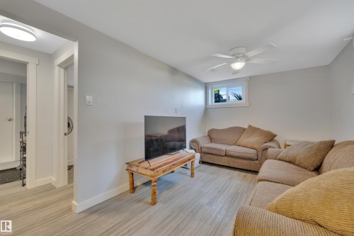 Recreation room with light gray walls and wood-finish flooring - 9835 74 Street, Edmonton, AB 