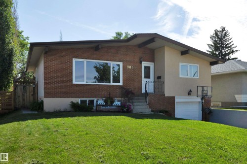 Brick and stucco exterior with multiple window styles, concrete front steps, and a single-door garage - 9835 74 Street, Edmonton, AB 
