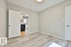 Interior room featuring light wood-finish flooring, neutral-toned walls, and a ceiling-mounted light fixture - 