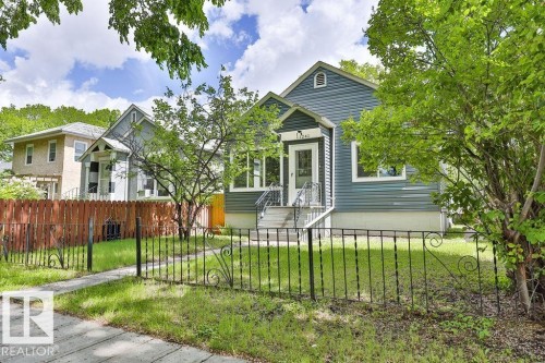 Blue siding exterior with a prominent front entry featuring white trim and a gabled porch roof - 11241 88 Street, Edmonton, AB 