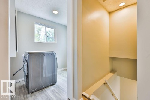 Laundry area featuring a window, recessed lighting, and wood-finish flooring - 11241 88 Street, Edmonton, AB 