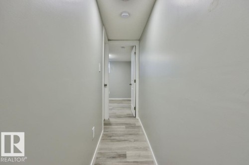 Hallway featuring light gray walls, recessed lighting, and wood-finish flooring - 11241 88 Street, Edmonton, AB 