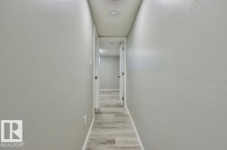 Hallway featuring light gray walls, recessed lighting, and wood-finish flooring - 