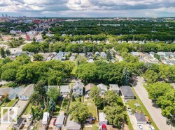Aerial perspective showcasing a residential neighborhood with a dense tree canopy - 