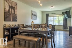 Spacious dining area featuring wood-finish flooring and a contemporary multi-bulb ceiling fixture - 