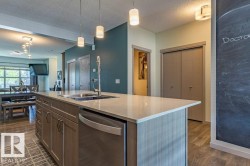 Kitchen island featuring a double-basin stainless steel sink, pull-down faucet, and integrated dishwasher - 