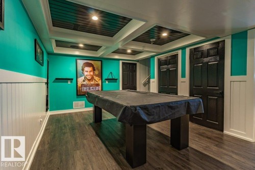 Recreational room featuring wood-finish flooring, white wainscoting, and a coffered ceiling with recessed lighting - 17123 49 Street, Edmonton, AB 