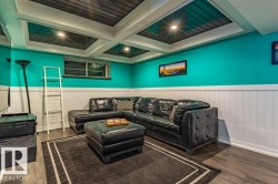 Recreational space featuring a coffered ceiling with recessed lighting, wood-finish flooring, and wainscoting - 
