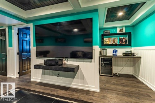 Entertainment area featuring vibrant teal walls and white beadboard paneling - 17123 49 Street, Edmonton, AB 