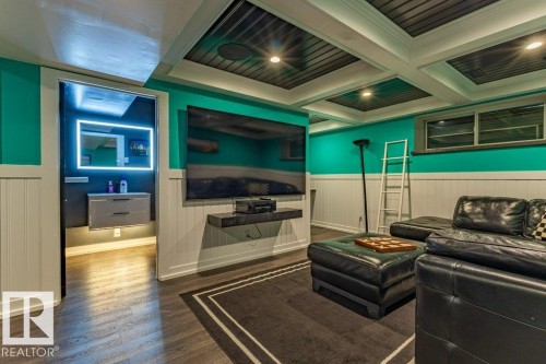 Lower-level living area featuring wood-finish flooring and wainscoting - 17123 49 Street, Edmonton, AB 