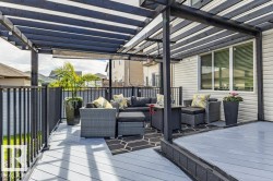 Expansive outdoor deck featuring a dark-stained pergola and gray composite decking - 