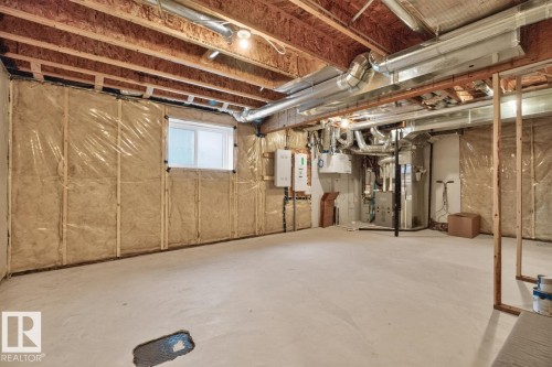 Unfinished basement area featuring exposed ceiling joists, framed walls with insulation and vapor barrier, and a concrete floor - 1022 Hearthstone Boulevard, Sherwood Park, AB 