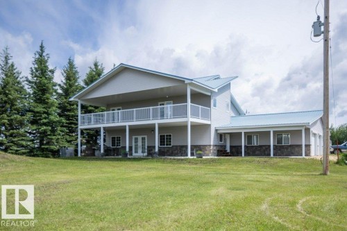 Contemporary home featuring light grey siding with stone accents and a blue metal roof - 58505 Rng Rd 260, Rural Westlock County, AB 
