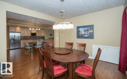 Open-concept living space featuring wood-finish flooring, a contemporary chandelier, and a built-in storage cabinet - 58505 Rng Rd 260, Rural Westlock County, AB 