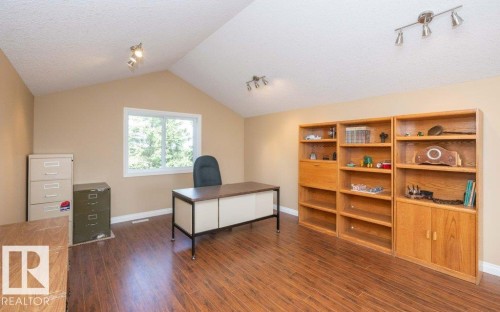 Room featuring wood-finish flooring, vaulted ceiling, and light beige wall paint - 58505 Rng Rd 260, Rural Westlock County, AB 