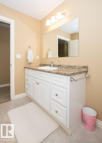 Bathroom vanity with white cabinetry, a stone-finish countertop, and an integrated sink with chrome faucet - 58505 Rng Rd 260, Rural Westlock County, AB 