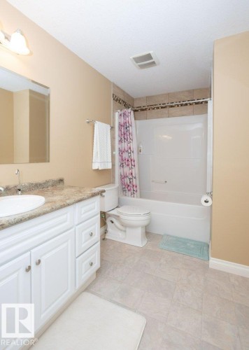 Bathroom featuring a white vanity with a stone-finish countertop, undermount sink, and chrome faucet - 58505 Rng Rd 260, Rural Westlock County, AB 