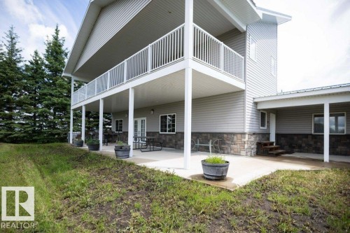 Multi-level exterior featuring light-colored siding and a stone facade - 58505 Rng Rd 260, Rural Westlock County, AB 