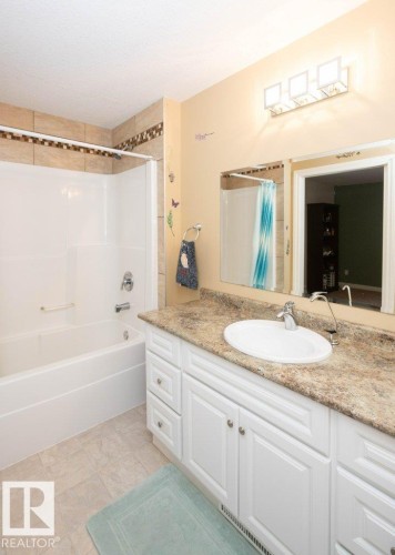 Bathroom featuring a white vanity with multiple cabinets and drawers, a light-colored countertop, and a white drop-in sink - 58505 Rng Rd 260, Rural Westlock County, AB 