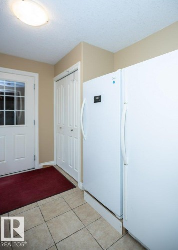 Neutral-toned ceramic tile flooring, a white paneled door with window inserts, and white bi-fold closet doors - 58505 Rng Rd 260, Rural Westlock County, AB 