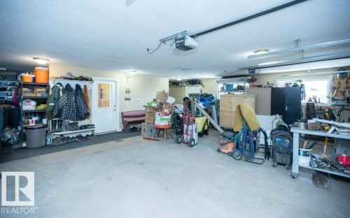 Spacious garage with multiple overhead garage doors, concrete flooring, and ample lighting fixtures - 58505 Rng Rd 260, Rural Westlock County, AB 