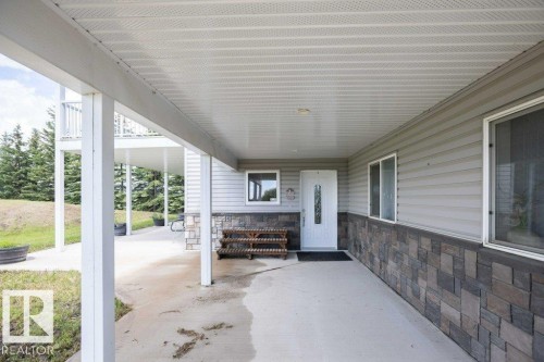 Covered concrete patio with white support columns - 58505 Rng Rd 260, Rural Westlock County, AB 