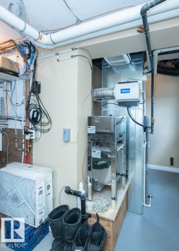 Utility area featuring mechanical systems, including a furnace with visible ductwork, a humidifier unit, and exposed plumbing - 58505 Rng Rd 260, Rural Westlock County, AB 