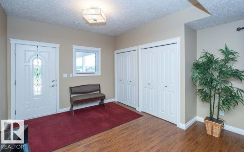 Entryway featuring wood-finish flooring, a white front door with decorative glass, and a small window for natural light - 58505 Rng Rd 260, Rural Westlock County, AB 