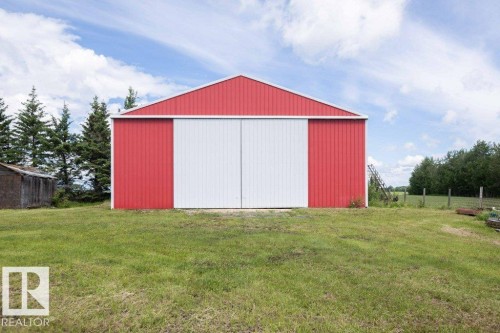 Red metal-clad outbuilding featuring white sliding barn doors - 58505 Rng Rd 260, Rural Westlock County, AB 
