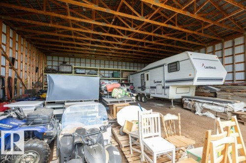 Spacious barn interior featuring exposed wooden rafters and vertical wooden siding - 58505 Rng Rd 260, Rural Westlock County, AB 