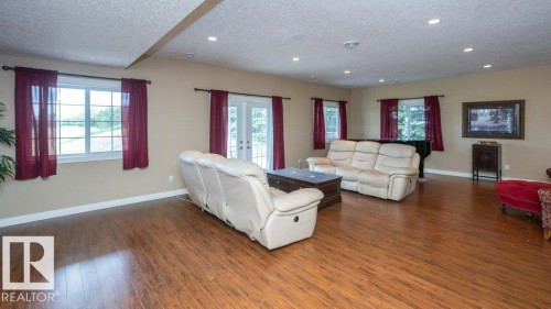Spacious living area featuring wood-finish flooring, neutral wall tones, and recessed lighting - 58505 Rng Rd 260, Rural Westlock County, AB 