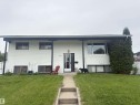 White siding exterior with black trim, concrete walkway, and established lawn - 66 Maligne Drive, Devon, AB  - Outdoor 