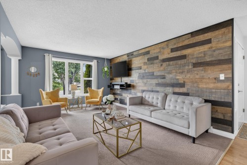 Living area featuring a prominent wood plank accent wall and light gray wall paint - 14612 29 Street Nw, Edmonton, AB 
